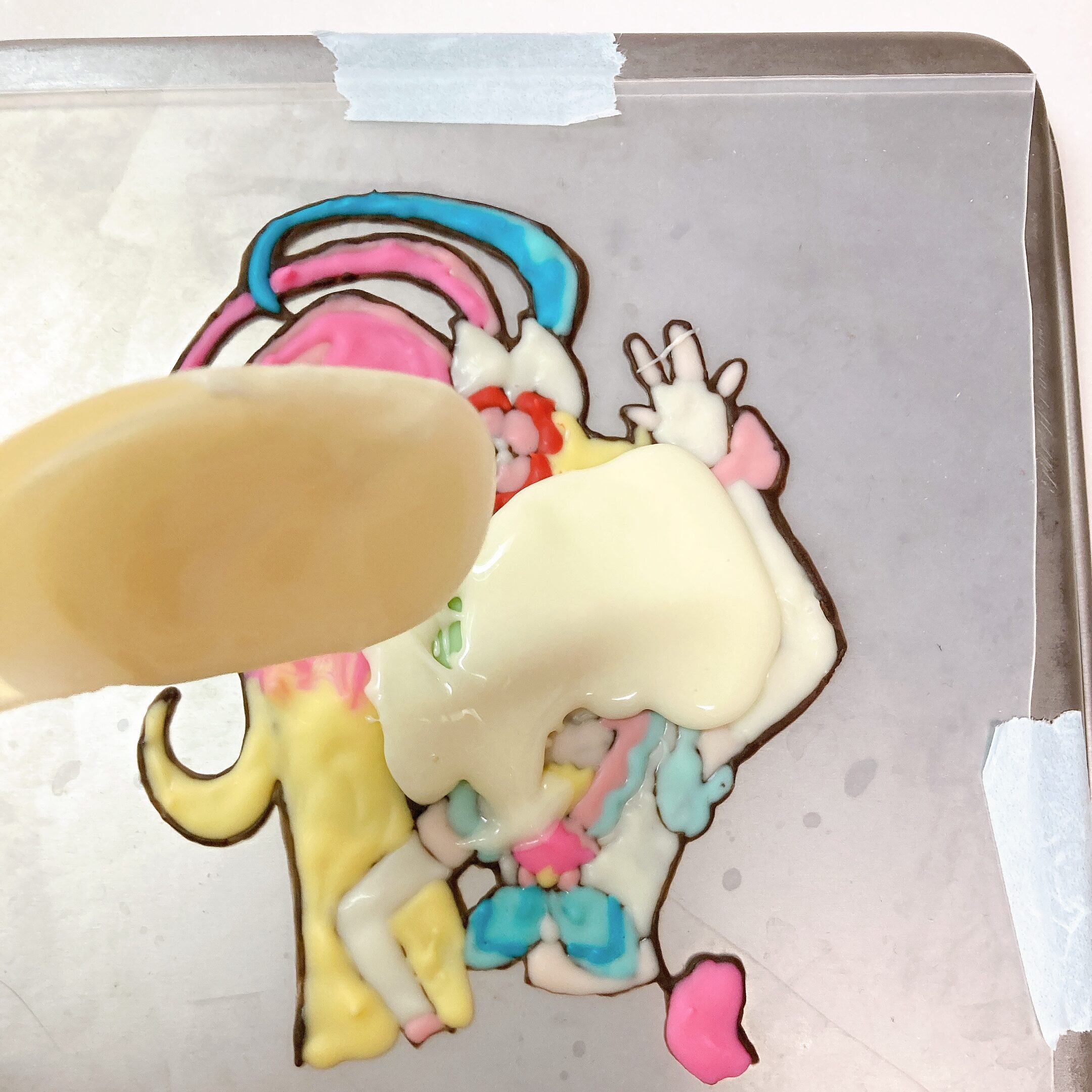 冷えたチョコレートの上からホワイトチョコレートをかけているようす